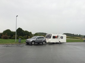Grey car on grey road under grey sky