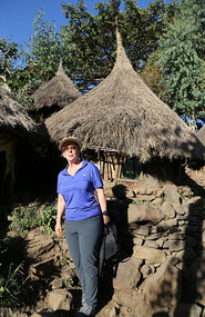 Leonie showing how "tall" the huts are (not)!