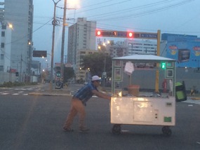 Street vendor pushing to his food cart to his site