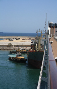 A Salalah tug jamming a ship in to its berth