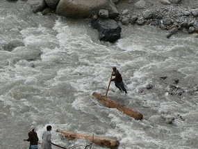 Men Moving Logs Using the River as Transport