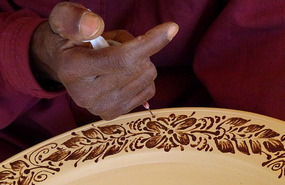 Artisan Makes Finishing Touches to a Ceramic Plate