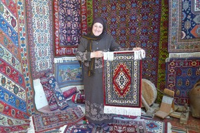 Friendly Carpet Shop Owner Displays Her Rugs