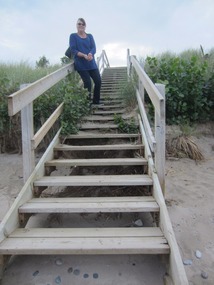 Arlene sitting on the rail of the beach access
