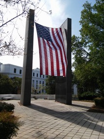 Two black pillars suspend an American flag