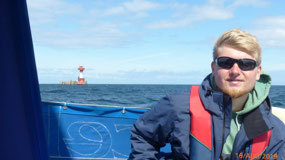 Jakob Bauer, helming; Kiel light behind