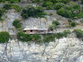 House clinging on to cliff