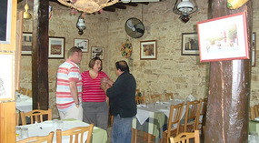 Taki talking with tourists in his Taverna