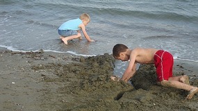 CHILDREN MAKING SUND CASTLES 