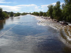 The Road Disappears Under A Raging River.