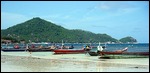 long tailed boats on shore