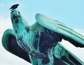 Bird on top of a bird statute