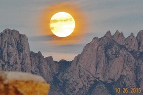 A FULL MOON OVER THE ORGAN MOUNTAINS.