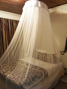 Mosquito net and bed at Chez Lando