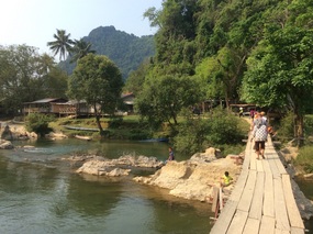 walking over a wooden bridge to the caves