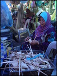 Lady making a mengkuang parcel in the market