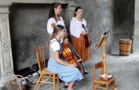THE TRIO OF MUSICIANS OUTSIDE THE CASTLE