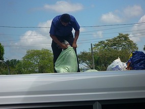- tying up the dog in plastic bag on top of bus
