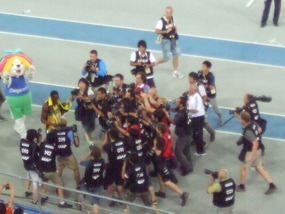 Victorious Usain Bolt with a mob of Media