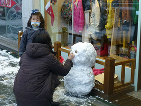 Storeowner Making Snowman