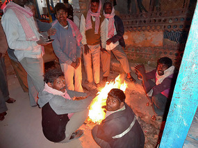 Guy warming by a fire in Old Ziro