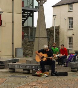 Guitarist sereneding outside church grounds