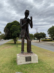 Sculpture of CJ Dennis in laura