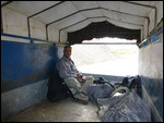On a sack of potatoes in the back of a truck