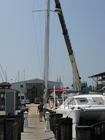 The crane swings the mast off deck
