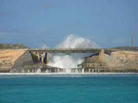 Waves crashing over the bridge at the Glass Window