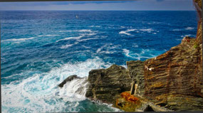 Waves crashing below by Cave Beach