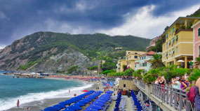Umbrellas, and people, cover the sandy beach