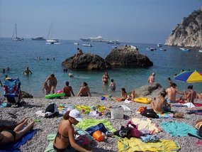 Bathers crammed on tiny beach of pebbles