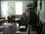Lois at the laptop on the dining table.