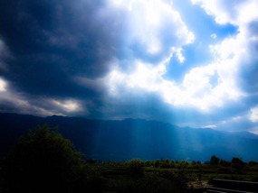 Sun breaking through clouds along Erhai Lake