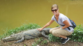 Alyssa pets a crocodile